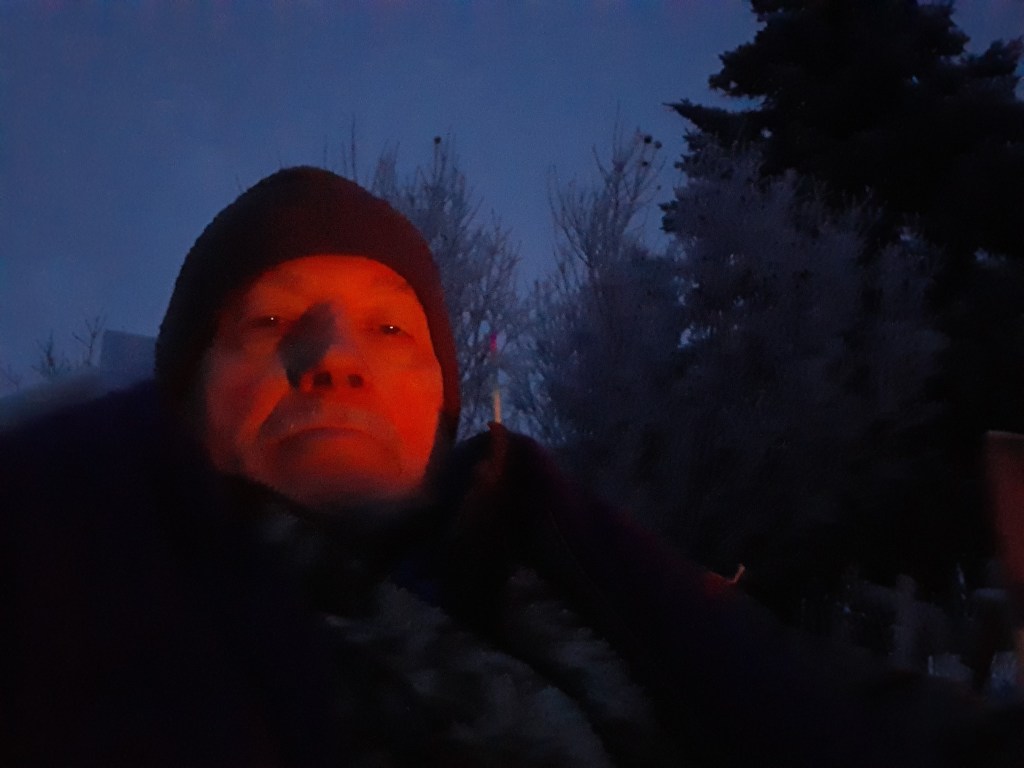 A person that is standing in the dark

Description automatically generated